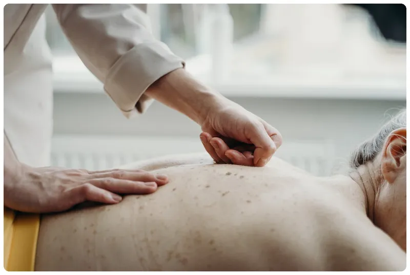 Fisioterapeuta realizando una masaje terapeutico en una espalda de un paciente